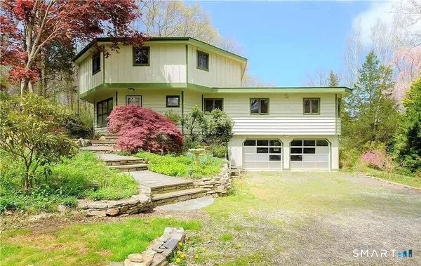 a front view of house with yard and trees around