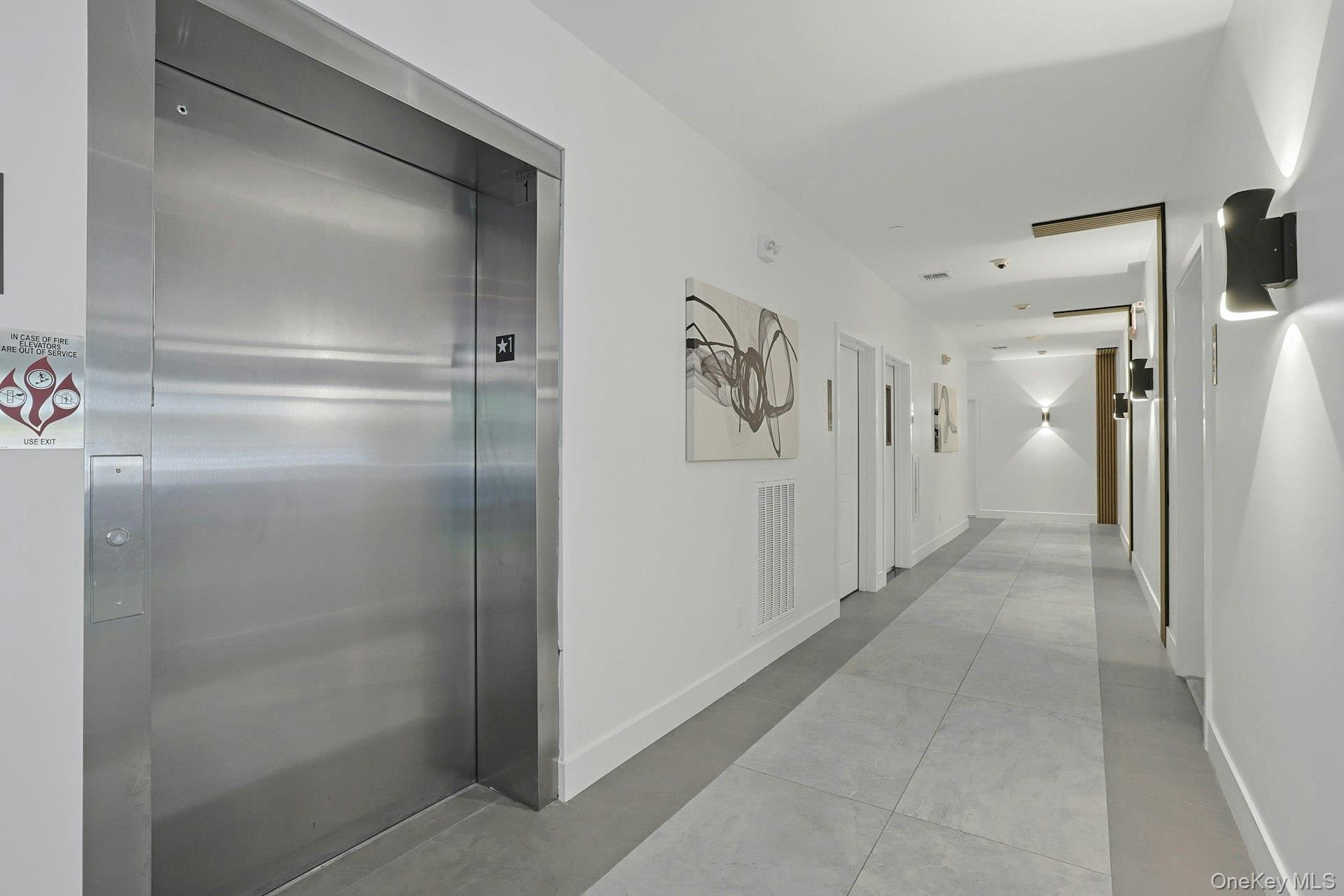962 Rte 9W, Unit 305 Congers, NY 10920 - Photo 3 of 24 Hallway featuring elevator and baseboards