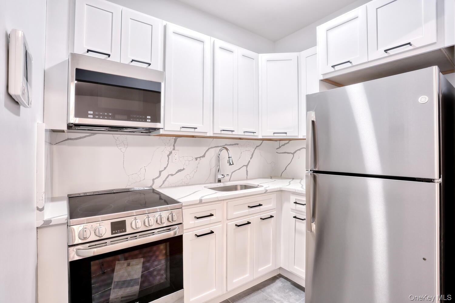 962 Rte 9W, Unit 305 Congers, NY 10920 - Photo 9 of 24 Beautiful stone counter and backsplash complete the kitchen.