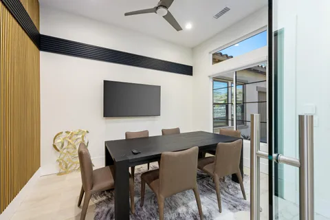 a view of a patio with couches table and chairs under an umbrella