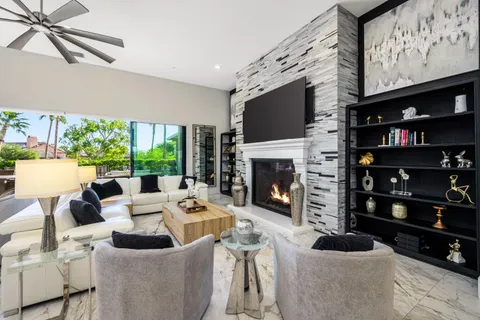 a living room with furniture a flat screen tv and a fireplace