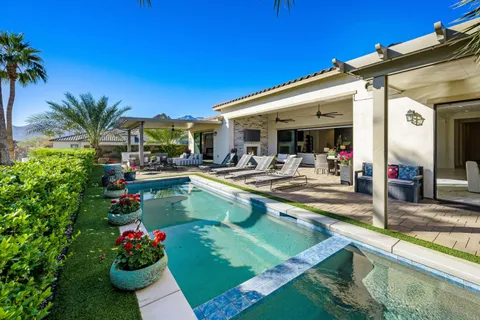 a view of a dining room with furniture a chandelier and large windows