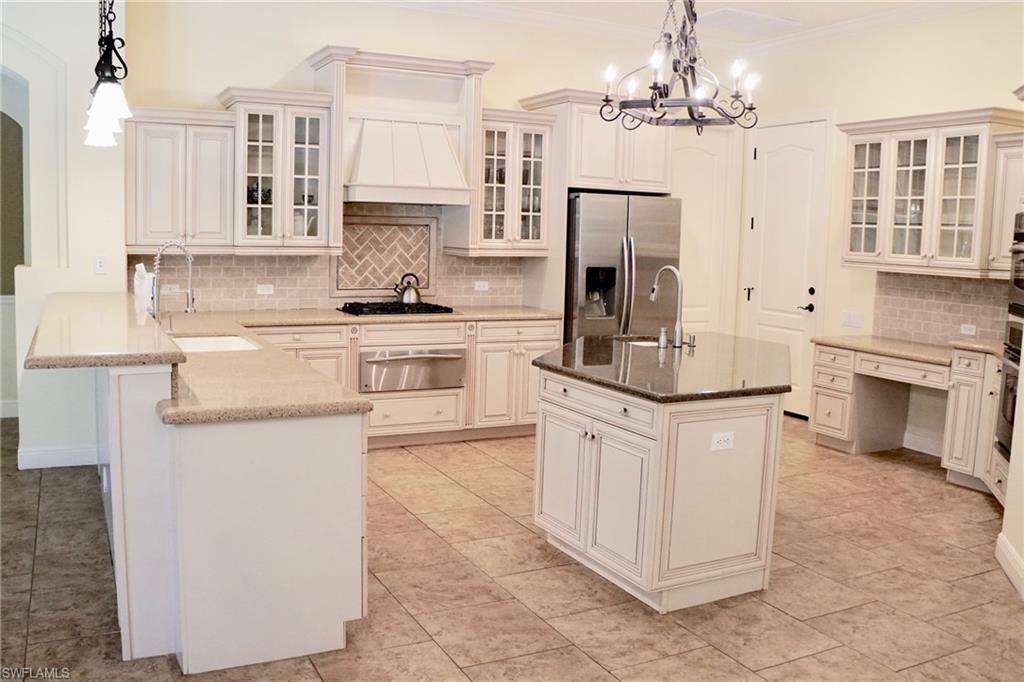 4231 Pine Ridge Road Naples, FL 34119 - Photo 4 of 18 a kitchen with stainless steel appliances granite countertop a refrigerator a stove a sink and white cabinets