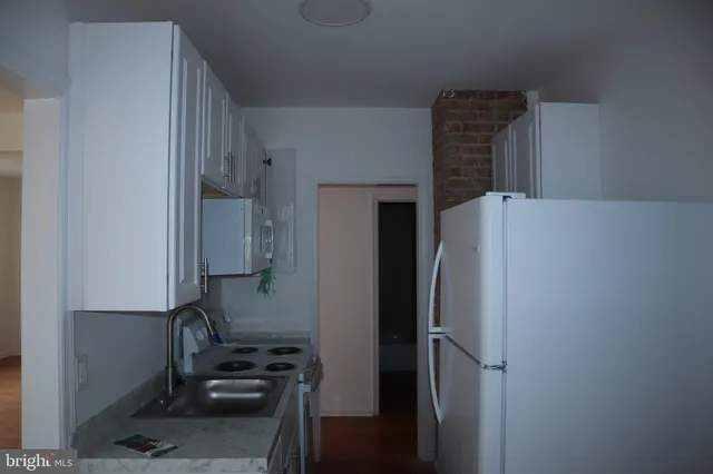 a kitchen with a refrigerator and a stove top oven
