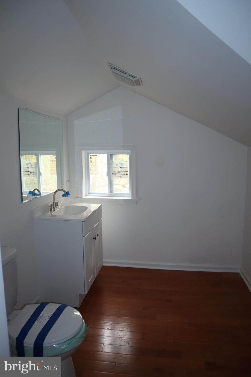 1004 Shepherd Street Northeast Washington, DC 20017 - Photo 19 of 28 a bathroom with a toilet a sink a mirror and a window