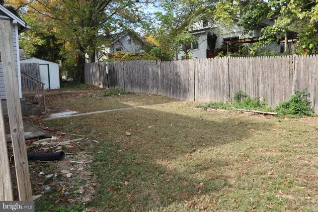 a view of backyard with wooden fence