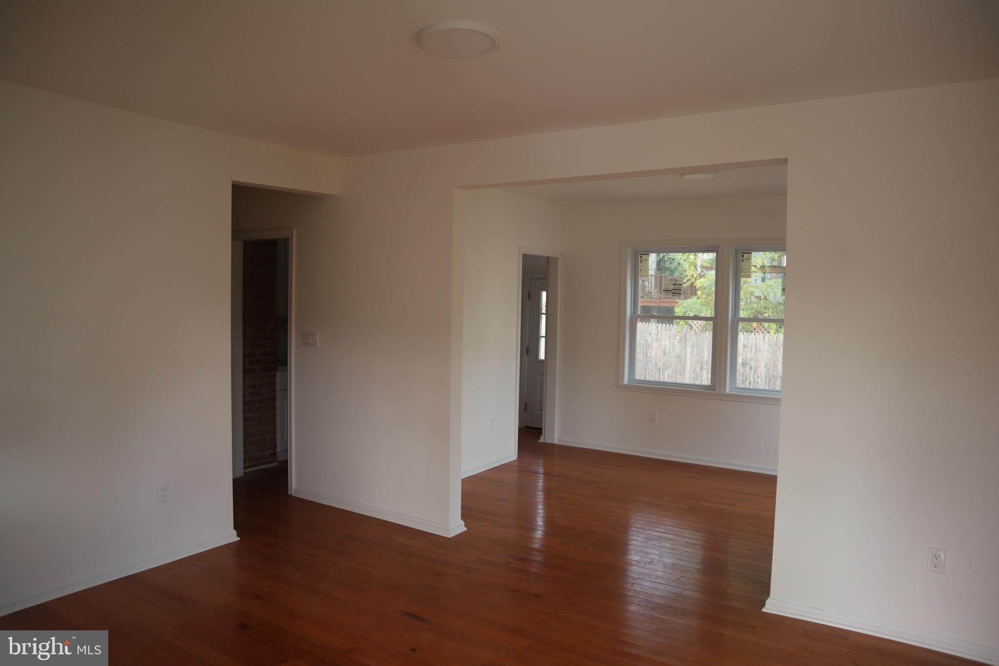 1004 Shepherd Street Northeast Washington, DC 20017 - Photo 7 of 28 a view of an empty room with wooden floor and a window