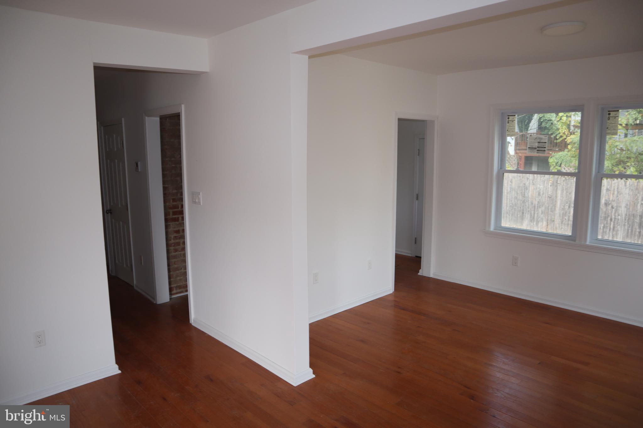 1004 Shepherd Street Northeast Washington, DC 20017 - Photo 8 of 28 an empty room with wooden floor and windows