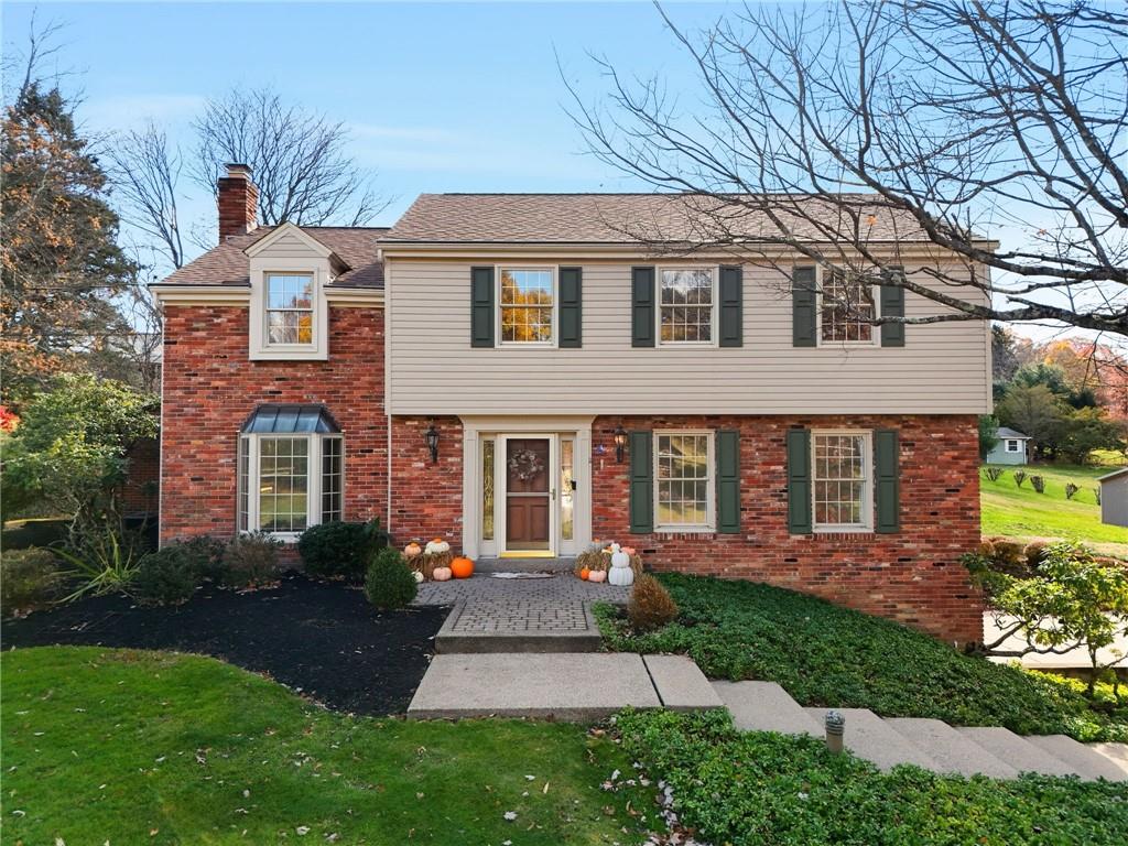a front view of a house with a yard and potted plants