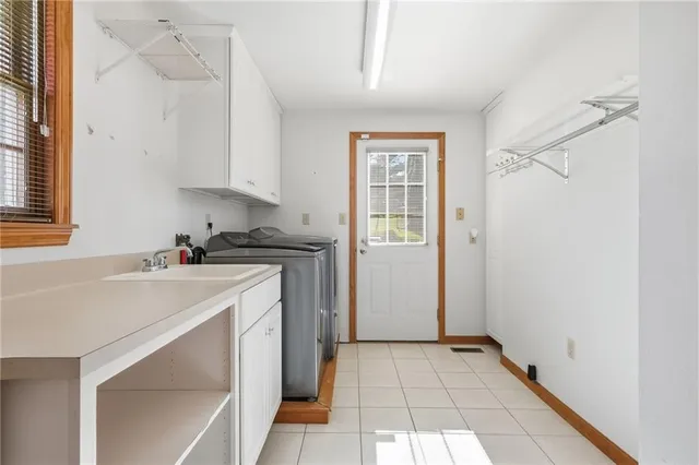 a utility room with cabinets washer and dryer
