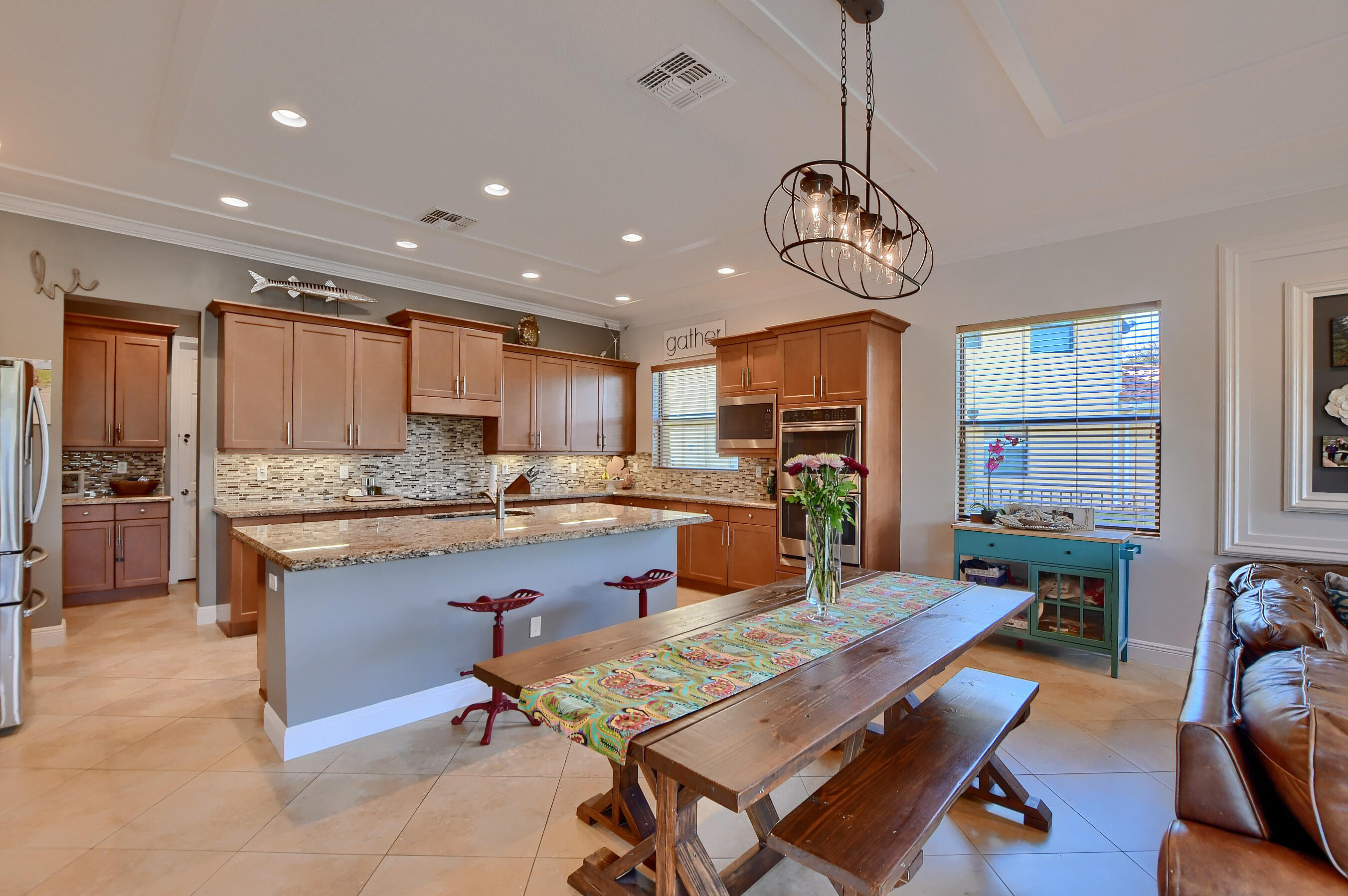 12161 Boca Reserve Lane Boca Raton, FL 33428 - Photo 29 of 53 a large kitchen with granite countertop lots of counter space dining table and stainless steel appliances