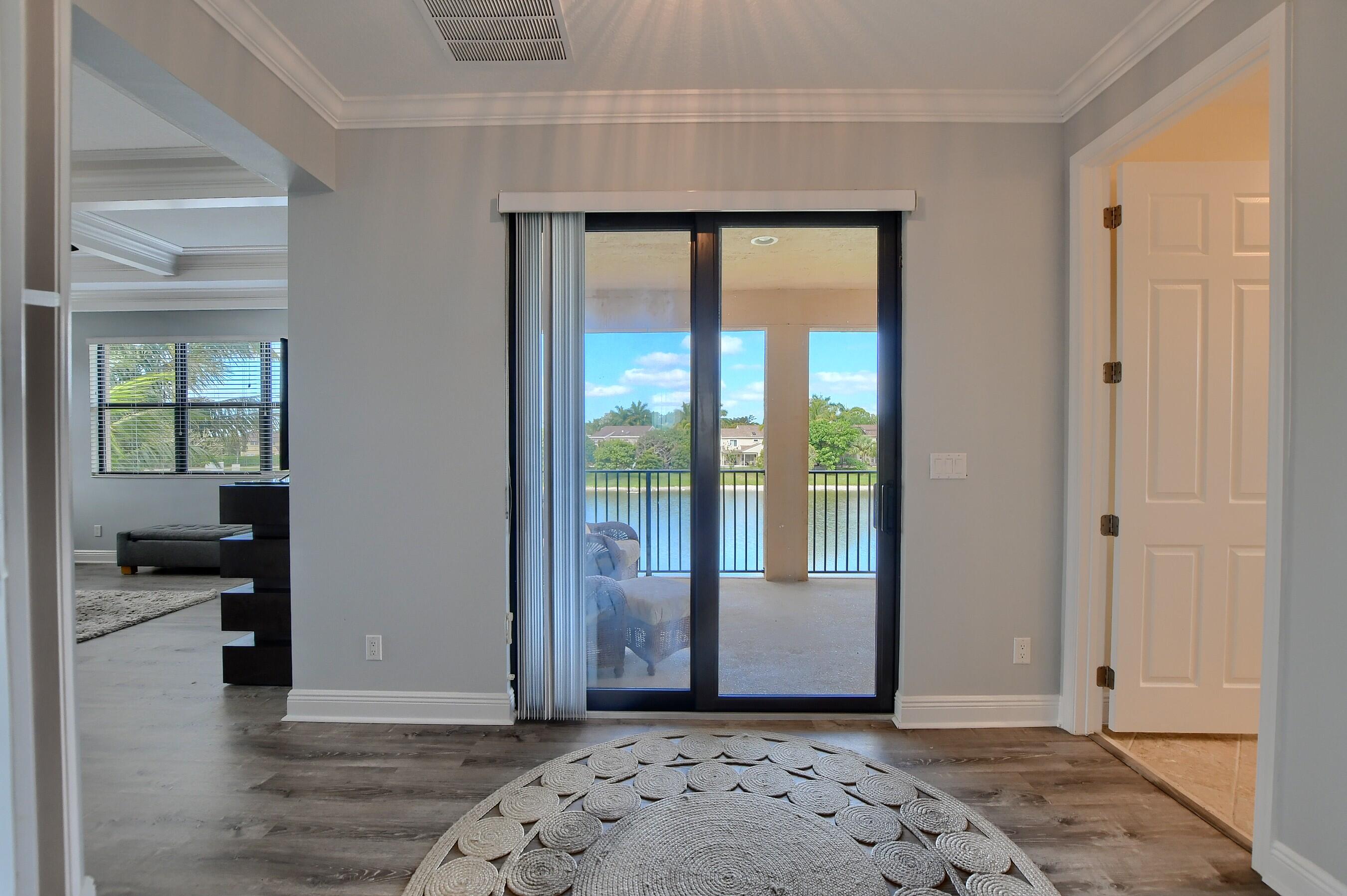 12161 Boca Reserve Lane Boca Raton, FL 33428 - Photo 40 of 53 a view of a hallway with wooden floor and a living room