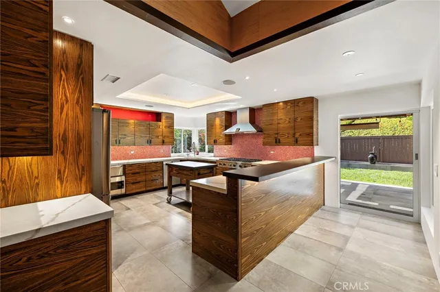 a large kitchen with stainless steel appliances granite countertop a barbecue grill and cabinets