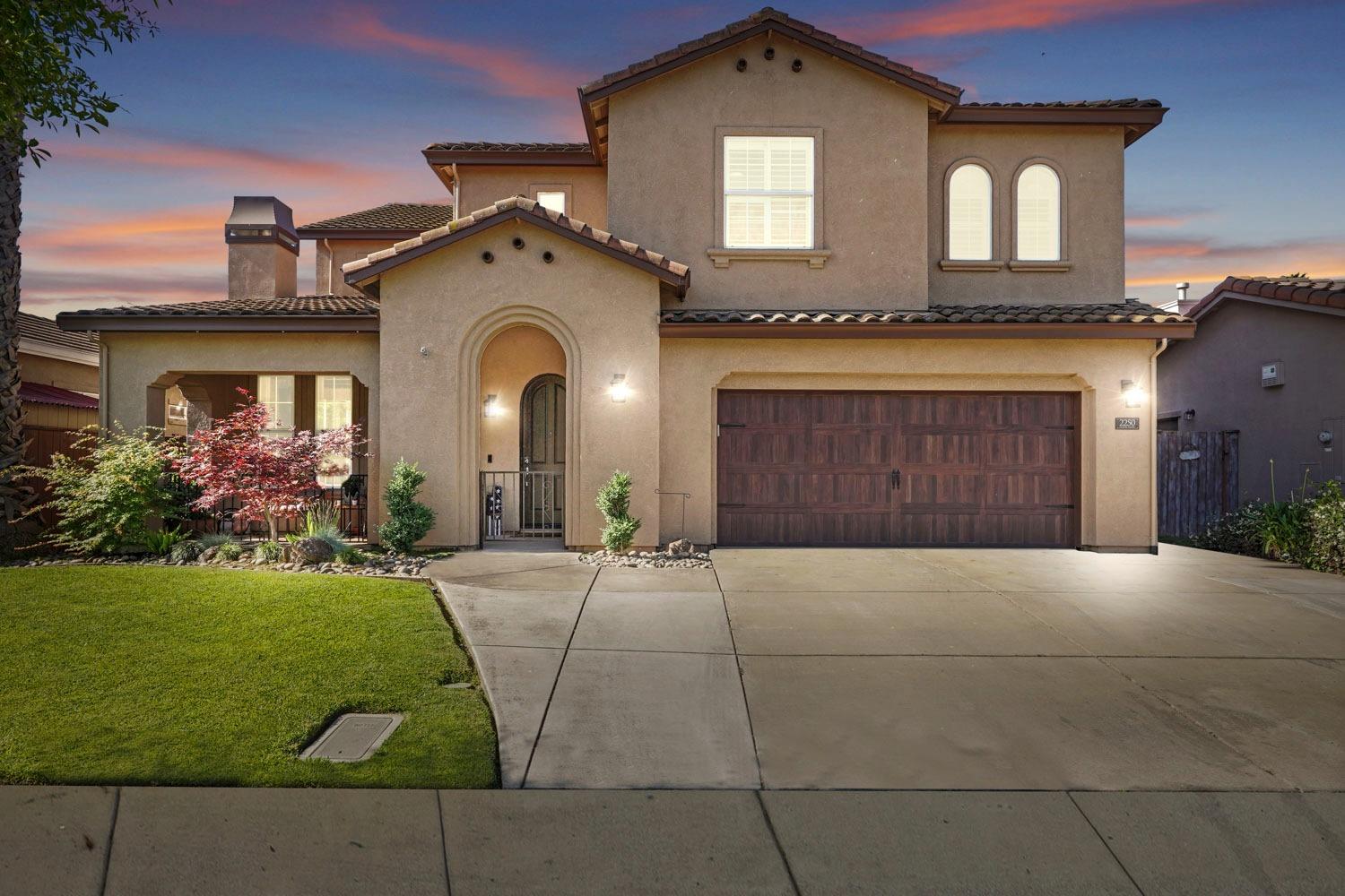 a front view of a house with a garden and a garage