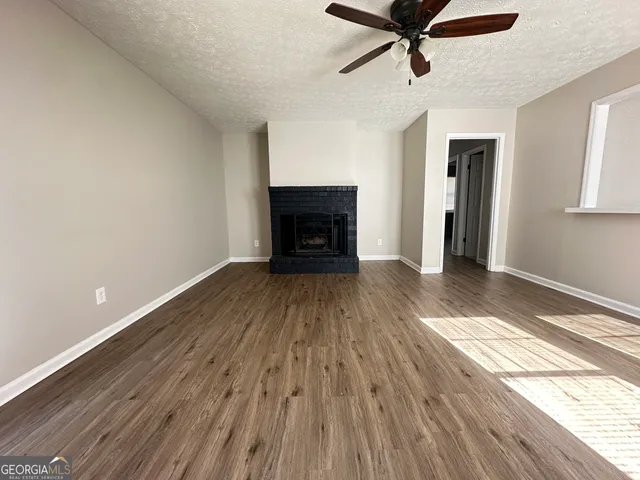 a view of empty room with wooden floor and fireplace