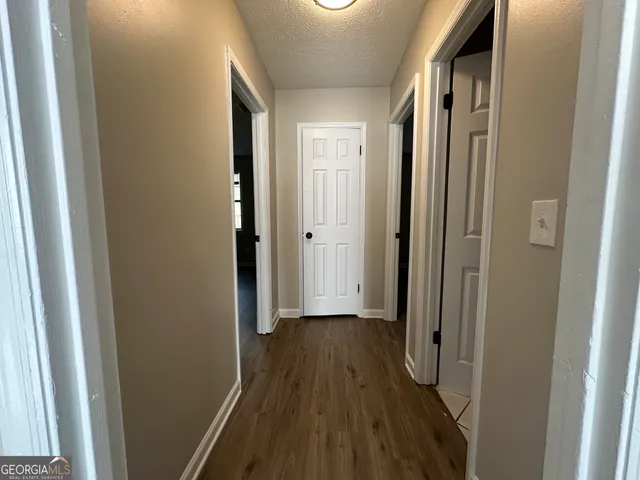 a view of a hallway with wooden floor and staircase