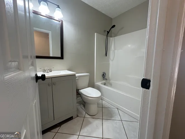 a bathroom with a toilet sink vanity and shower