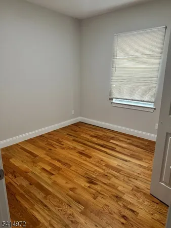 a view of a room with an empty space and wooden floor