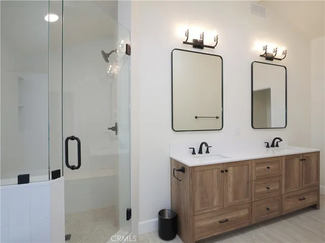 a bathroom with a double vanity sink mirror and bathtub