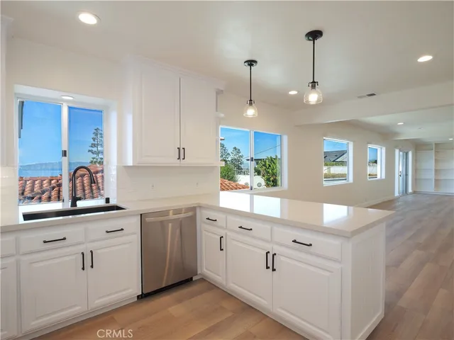 a kitchen with cabinets stainless steel appliances and wooden floor