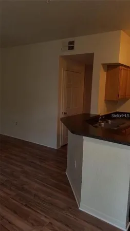 a kitchen with granite countertop white cabinets and black appliances