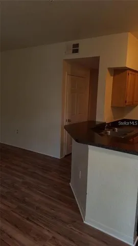 a kitchen with granite countertop white cabinets and black appliances