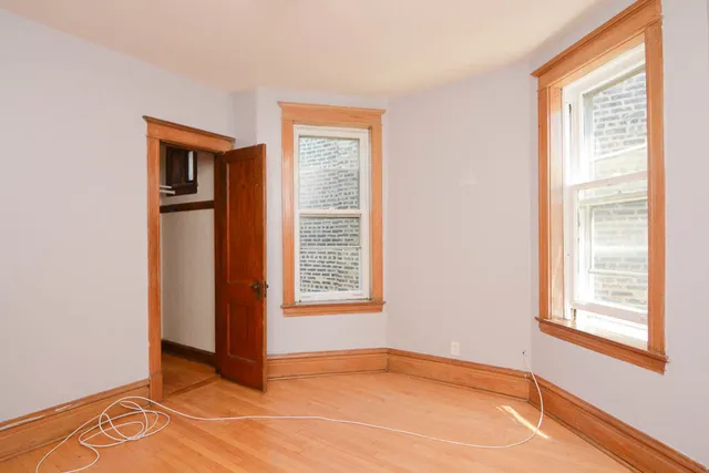 a view of an empty room with window and closet area