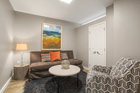 a living room with furniture and a lamp