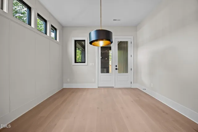 a view of a hallway with wooden floor and stairs