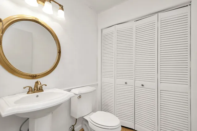 a bathroom with a sink a toilet and a mirror