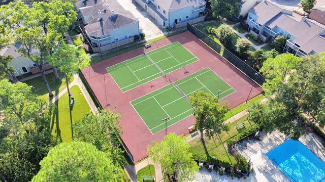 an aerial view of a tennis ground and a houses
