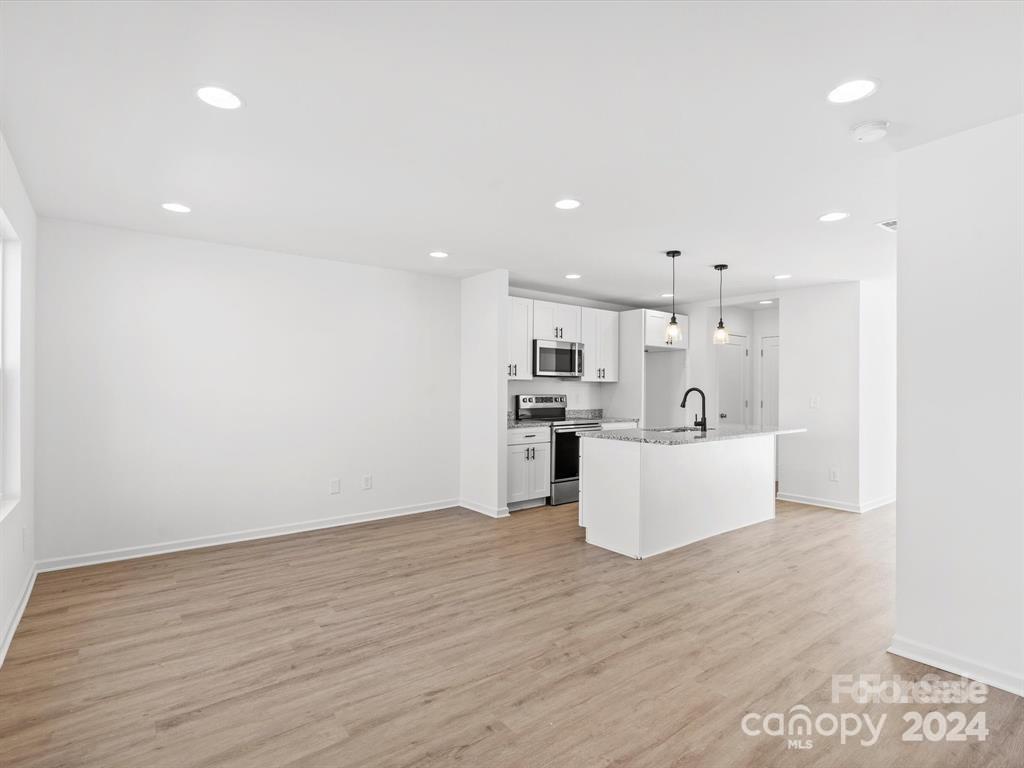 3799 Herman Sipe Road, Unit B Conover, NC 28613 - Photo 29 of 44 a view of kitchen with kitchen island sink refrigerator and white cabinets with wooden floor