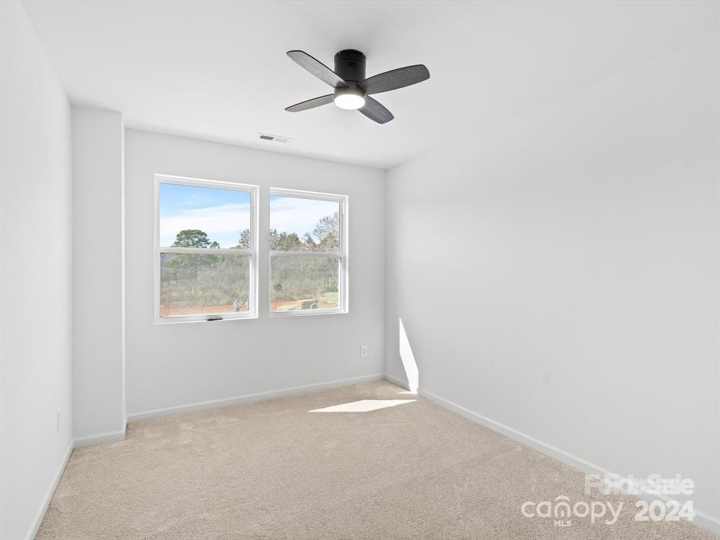 3799 Herman Sipe Road, Unit B Conover, NC 28613 - Photo 35 of 44 an empty room with a window and a ceiling fan