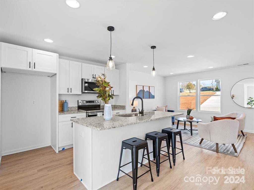 3799 Herman Sipe Road, Unit B Conover, NC 28613 - Photo 8 of 44 a kitchen with stainless steel appliances kitchen island granite countertop a table chairs stove and white cabinets