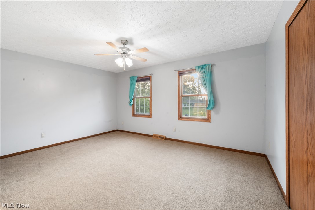 1239 Congress Lake Road Mogadore, OH 44260 - Photo 23 of 35 Unfurnished room with carpet, ceiling fan, and a textured ceiling