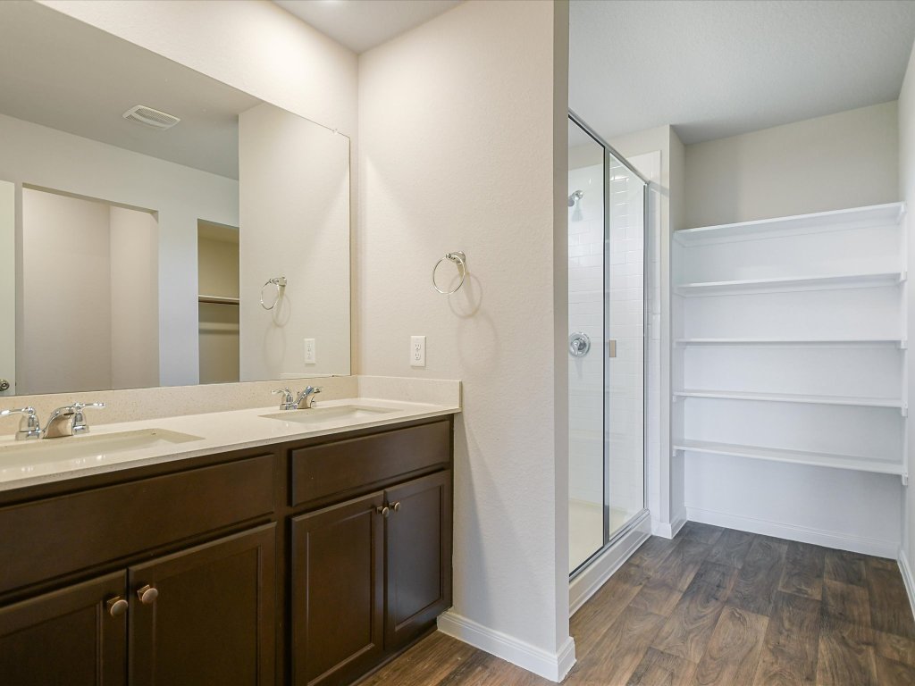 14408 Boquist Drive Pflugerville, TX 78660 - Photo 12 of 20 a bathroom with a double vanity sink and mirror