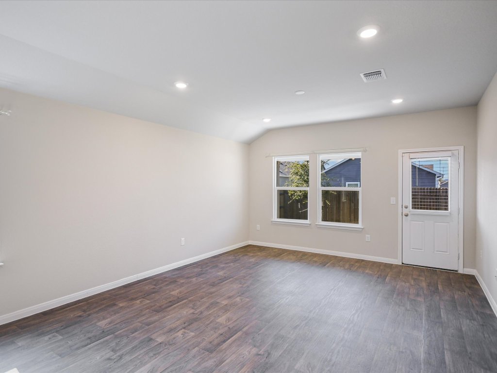 14408 Boquist Drive Pflugerville, TX 78660 - Photo 6 of 20 a view of an empty room with a window and wooden floor