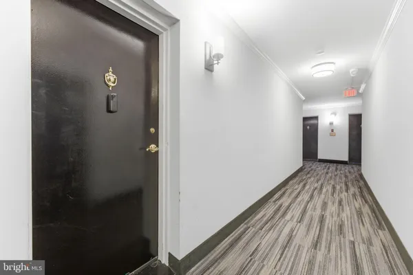 a view of a hallway with closet and wooden floor