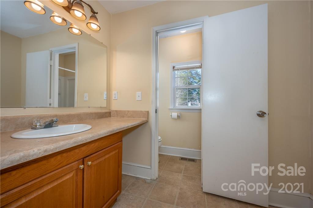 291 Cardinal Street Inman, SC 29349 - Photo 20 of 40 a bathroom with a granite countertop sink a light fixture and a mirror