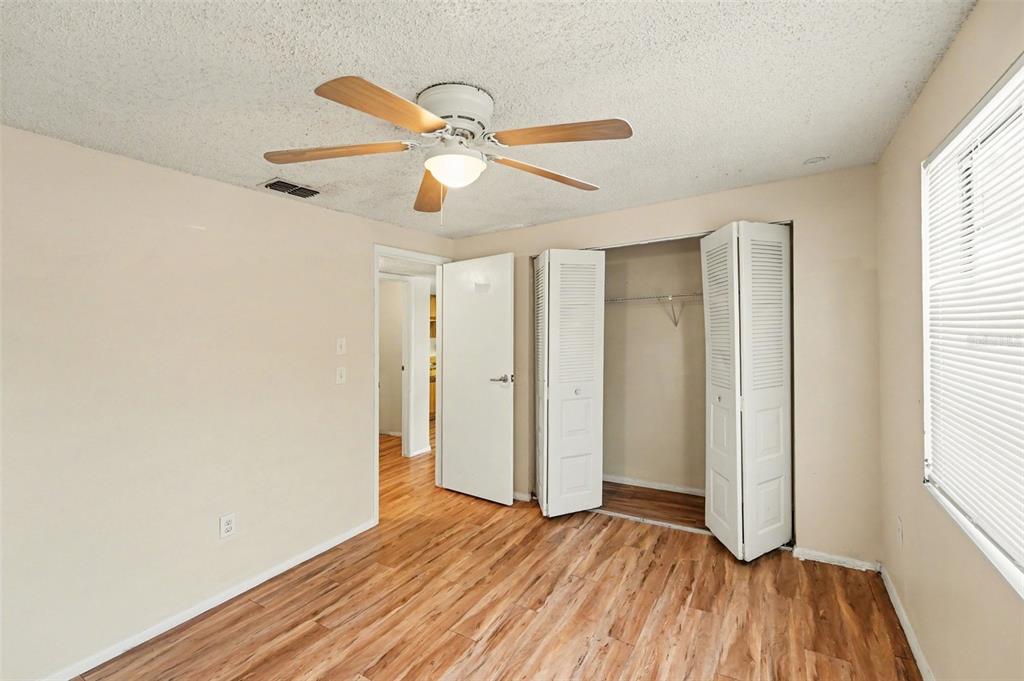 129 Camphor Circle, Unit F Oldsmar, FL 34677 - Photo 16 of 38 a view of empty room with wooden floor and fan