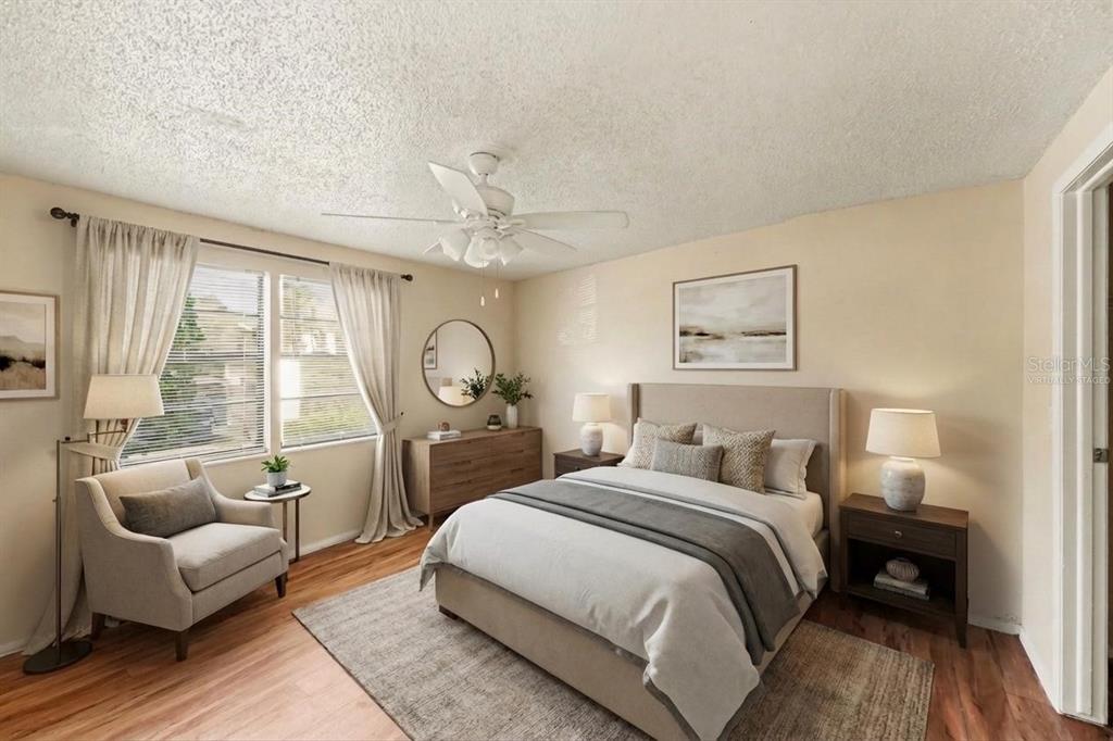 129 Camphor Circle, Unit F Oldsmar, FL 34677 - Photo 18 of 38 a bedroom with a bed a couch and large window