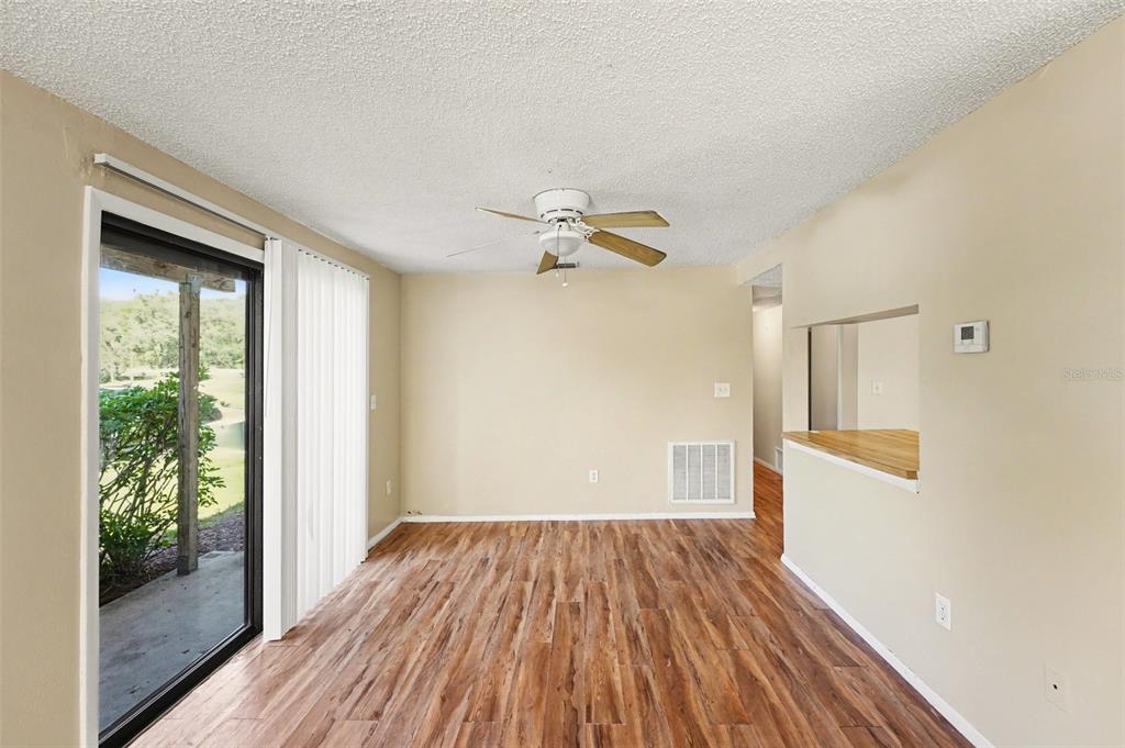 129 Camphor Circle, Unit F Oldsmar, FL 34677 - Photo 24 of 38 a view of a room with wooden floor and a ceiling fan