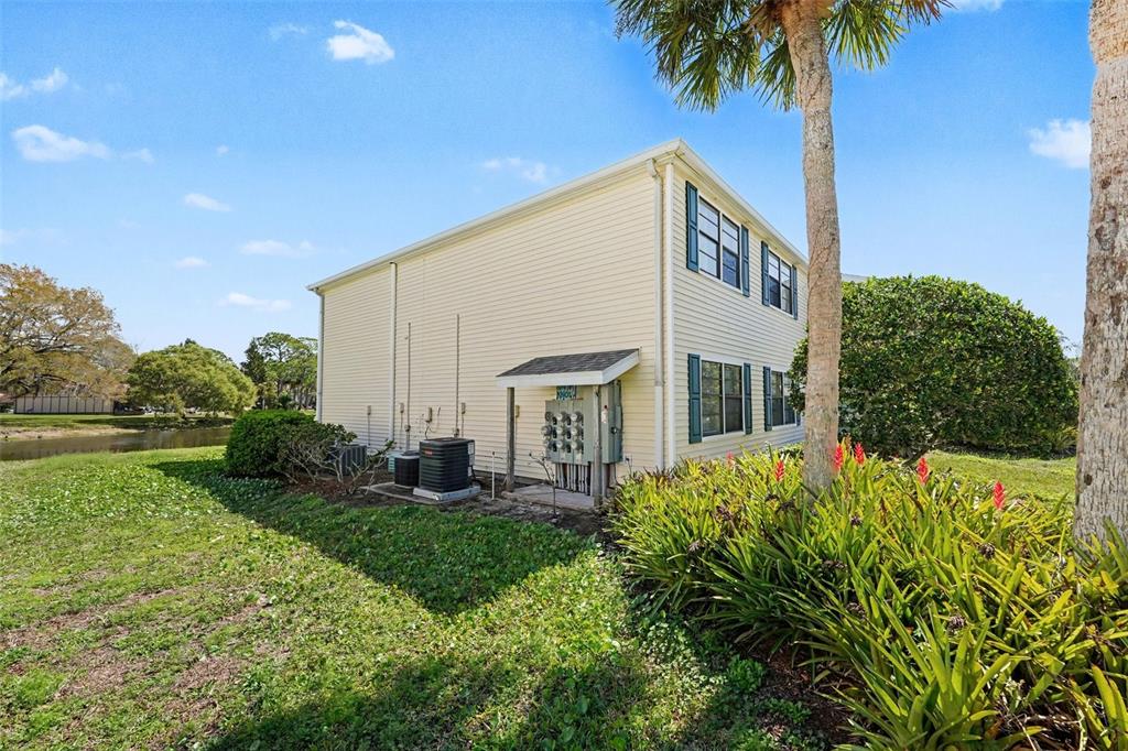 129 Camphor Circle, Unit F Oldsmar, FL 34677 - Photo 29 of 38 a view of a house with a yard and potted plants