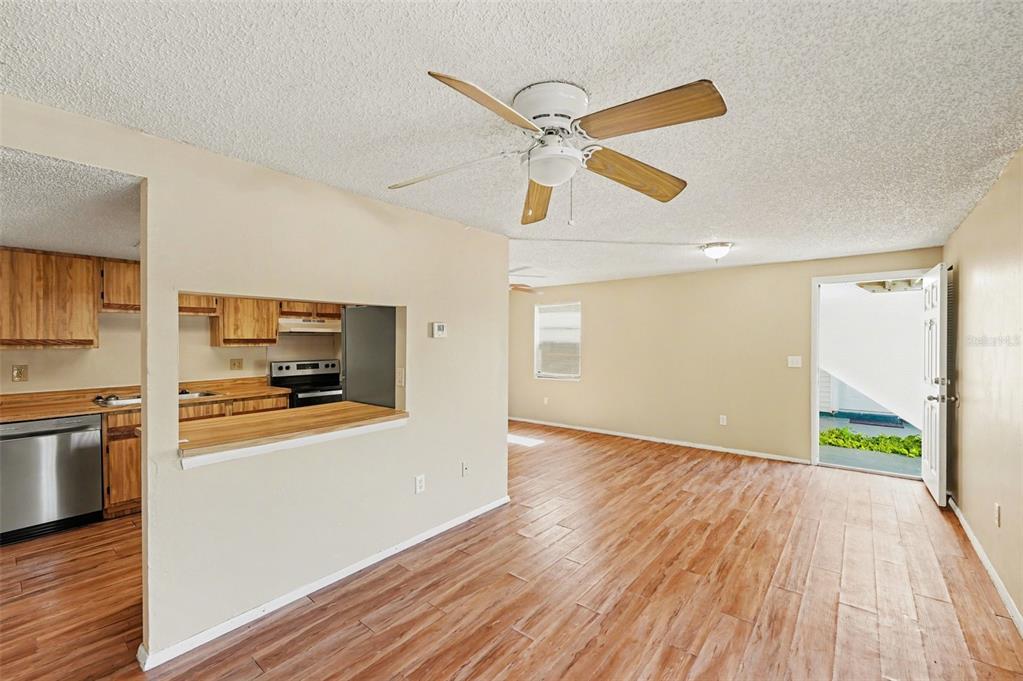 129 Camphor Circle, Unit F Oldsmar, FL 34677 - Photo 8 of 38 a view of a kitchen with wooden floor a sink and a refrigerator