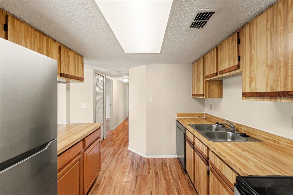 129 Camphor Circle, Unit F Oldsmar, FL 34677 - Photo 10 of 38 a kitchen with granite countertop a sink stove and refrigerator