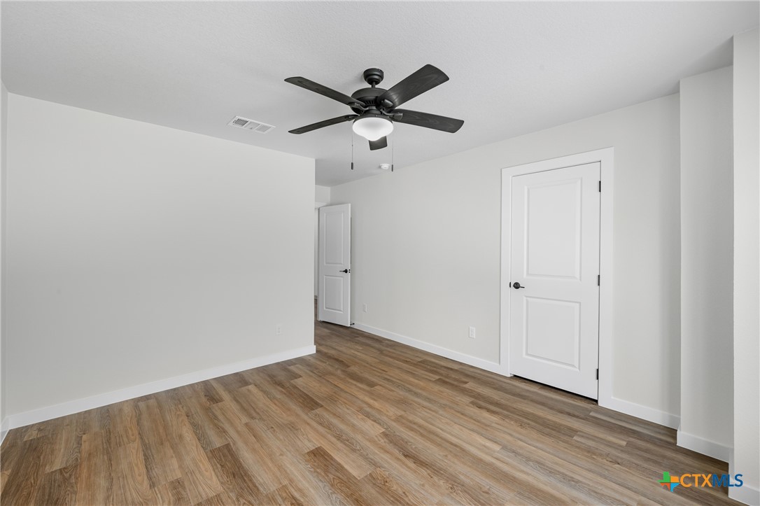 905 Martin Luther King Jr Lane, Unit B Temple, TX 76504 - Photo 16 of 24 a view of a room with wooden floor and a ceiling fan