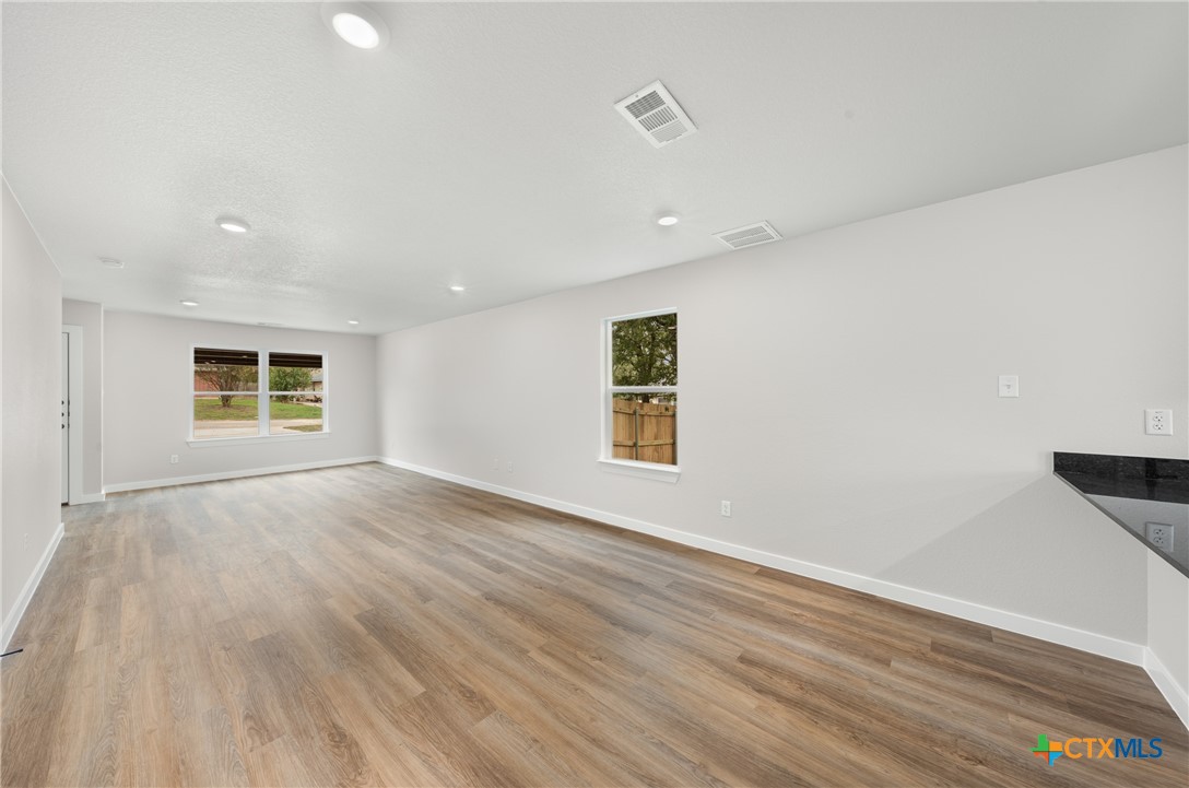 905 Martin Luther King Jr Lane, Unit B Temple, TX 76504 - Photo 5 of 24 an empty room with wooden floor and windows