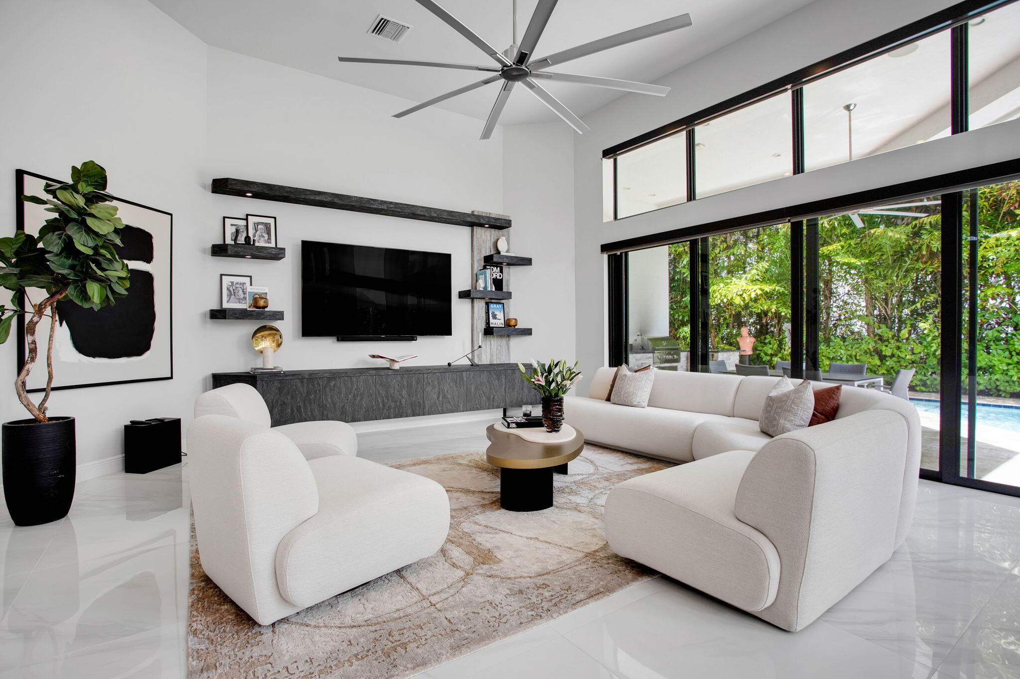6903 Northwest 28th Avenue Boca Raton, FL 33496 - Photo 17 of 69 a living room with furniture a flat screen tv and a floor to ceiling window