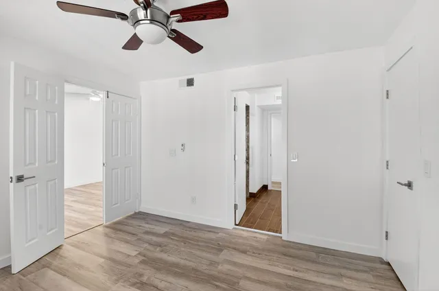 a view of a hallway with wooden floor and closet area