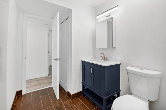 a bathroom with a toilet a sink and a mirror